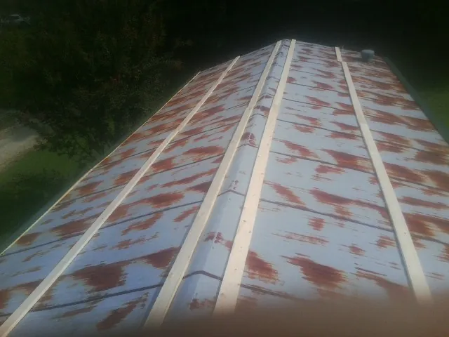 Rusted metal roof panels with new wood purlins before replacement — Storm Damage Roof Repair in Dillwyn by Roofing Brothers
