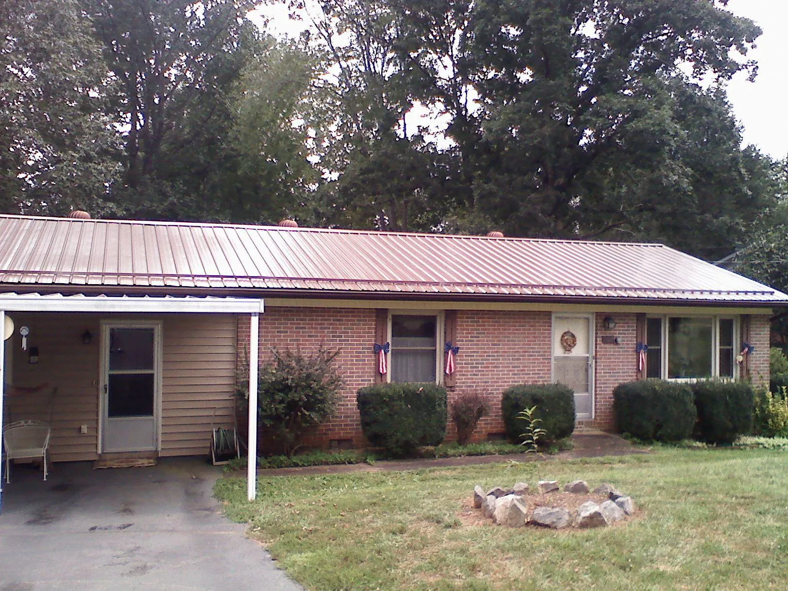 Bronze metal roof and carport on a brick ranch home — Roof Repair work by our crew in Dillwyn